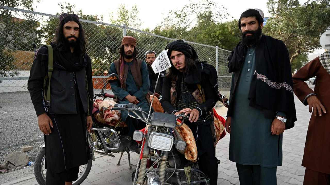 Taliban fighters stand along a road in Kabul. Credit: AFP Photo