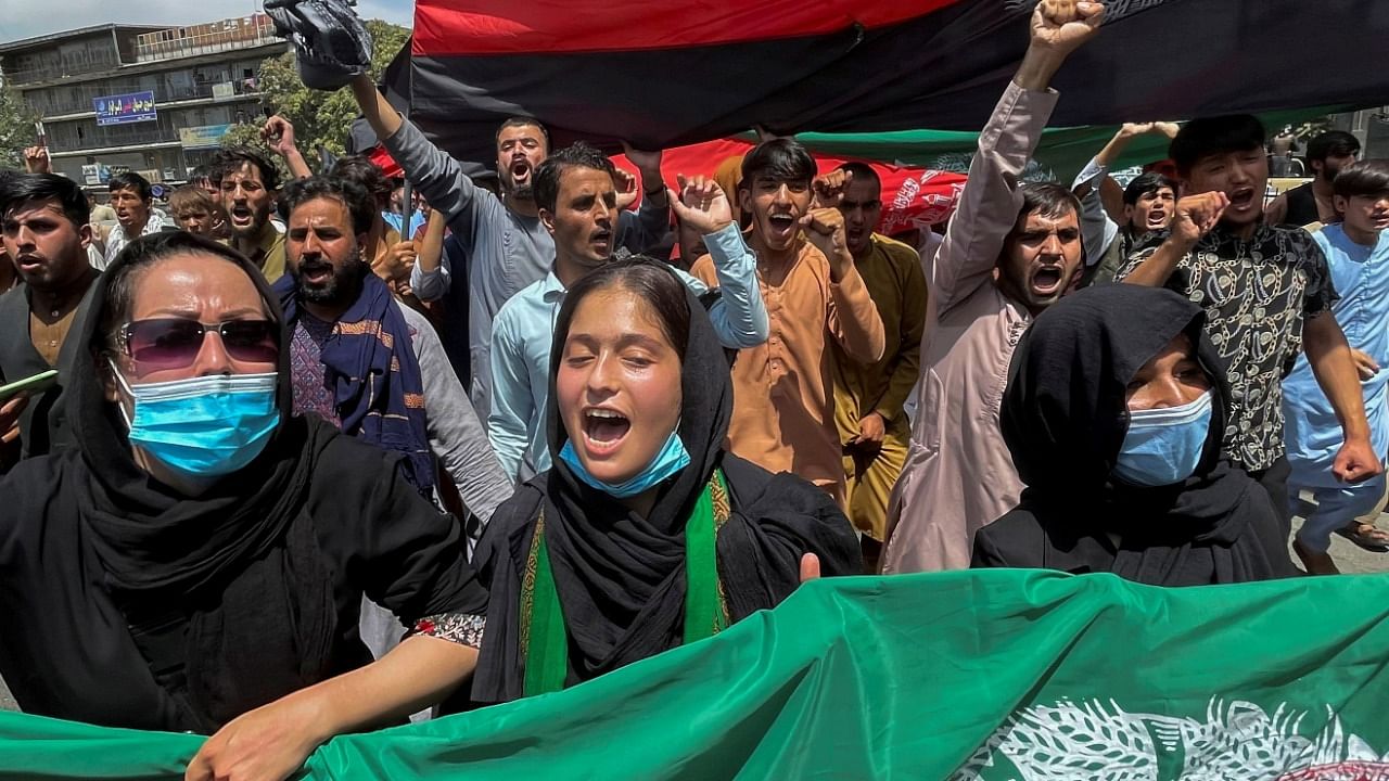 People carry the national flag at a protest held during the Afghan Independence Day in Kabul, Afghanistan. Credit: Reuters Photo