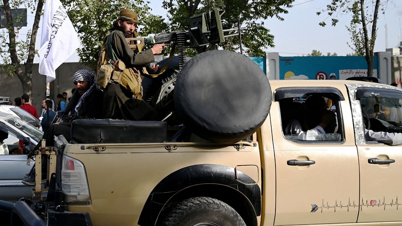 Taliban fighters travel with weapons mounted on a vehicle in Kabul, Credit: AFP Photo
