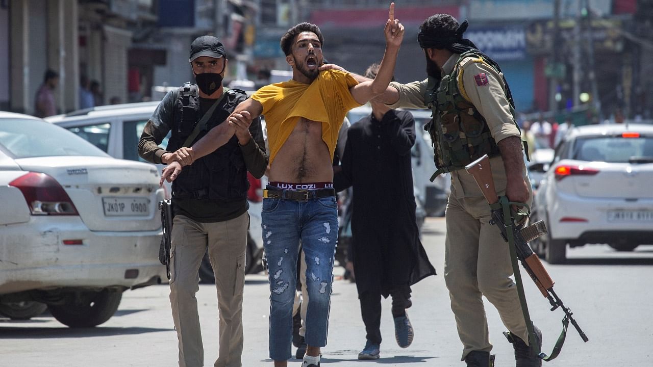 Policemen detain a Kashmiri Shiite Muslim as devotees defy restrictions for a Muharram procession in Srinagar. Credit: AFP File Photo