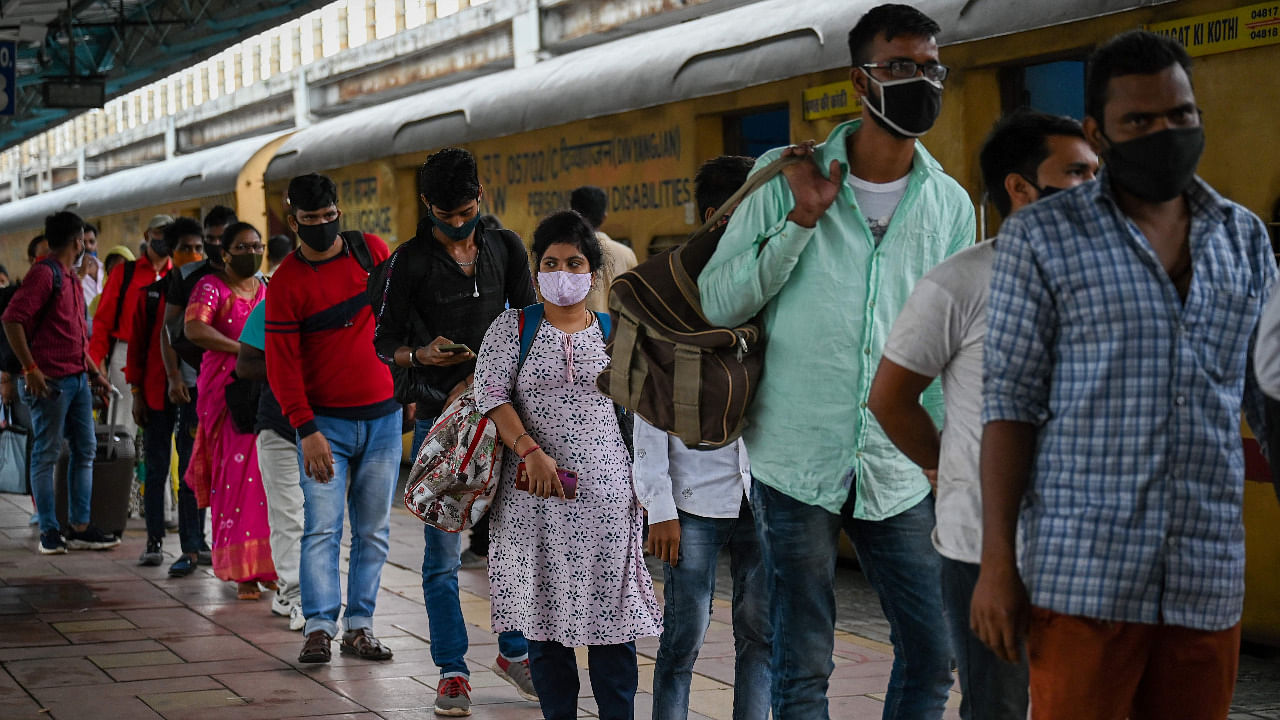 Passengers queue up for the Covid-19 screening after arriving at a railway platform on a long distance train, in Mumbai. Credit: AFP Photo