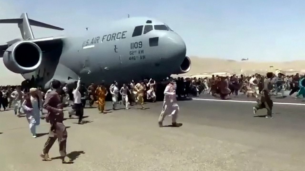 In a harrowing video from the airport on Monday, hundreds of people were seen running alongside a US Air Force plane as it gathered speed on the runway. Credit: AP/PTI Photo