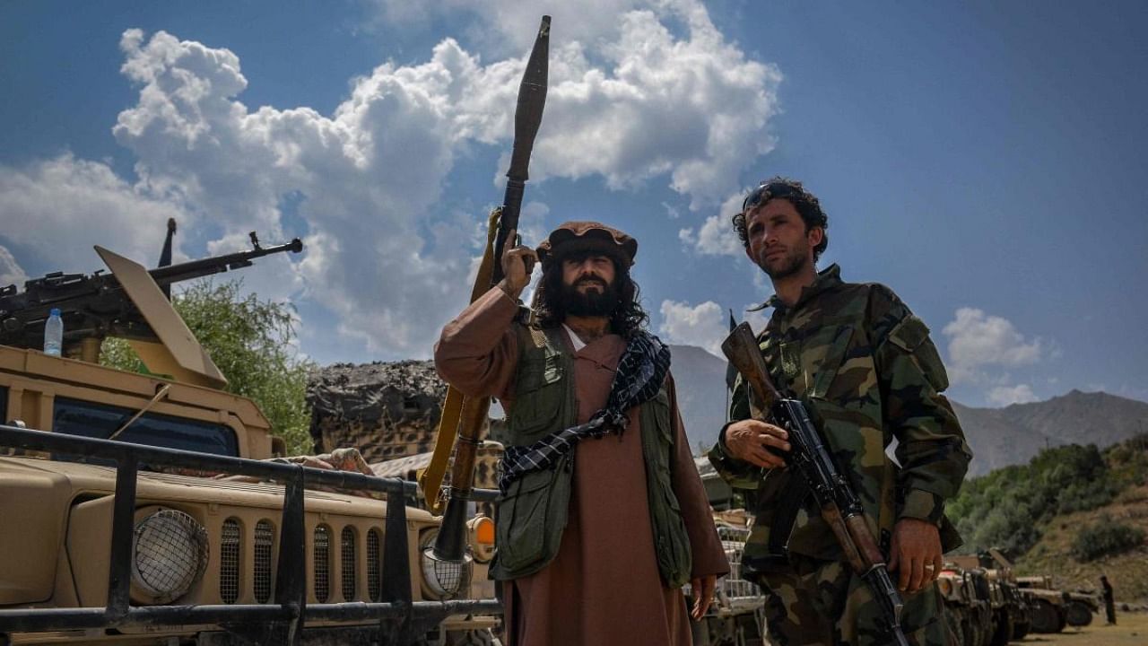 Afghan armed men supporting the Afghan security forces against the Taliban stand with their weapons and Humvee vehicles at Parakh area in Bazarak, Panjshir province on August 19, 2021. Credit: AFP Photo