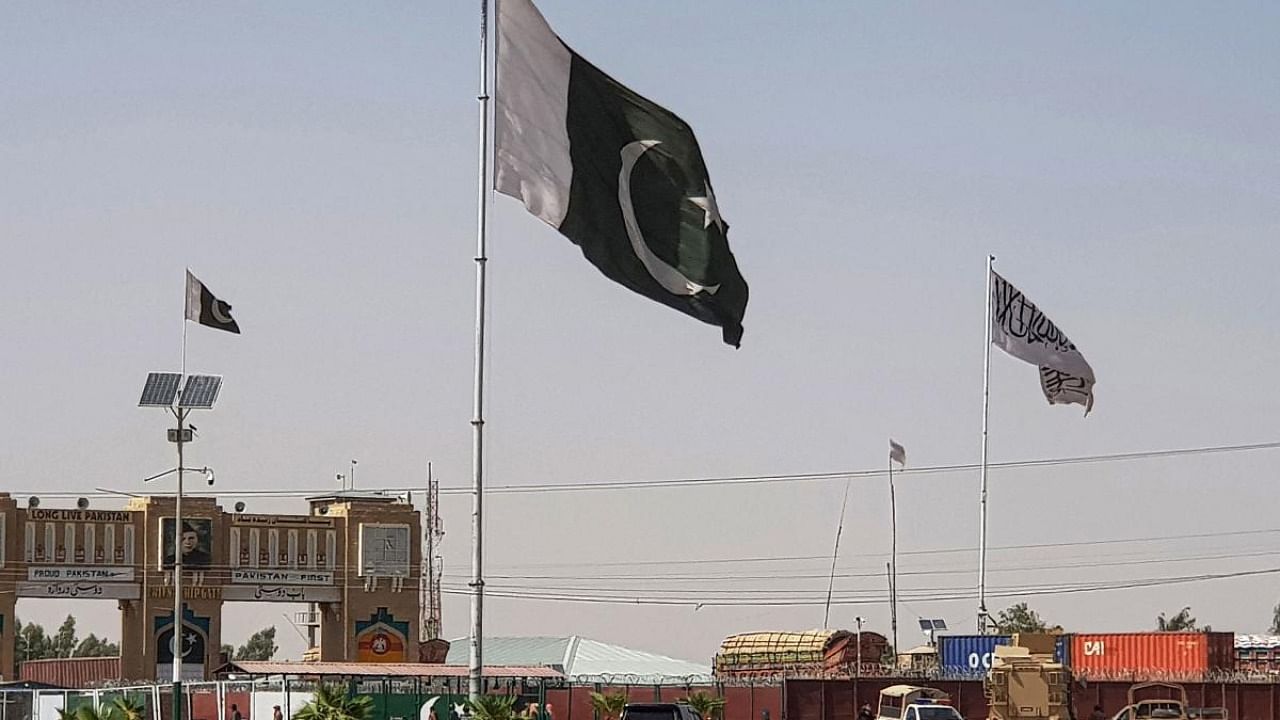 Pakistani flags (C) and Taliban flag (R) flutter on their respective border sides as seen from the Pakistan-Afghanistan border crossing point in Chaman. Credit: AFP Photo