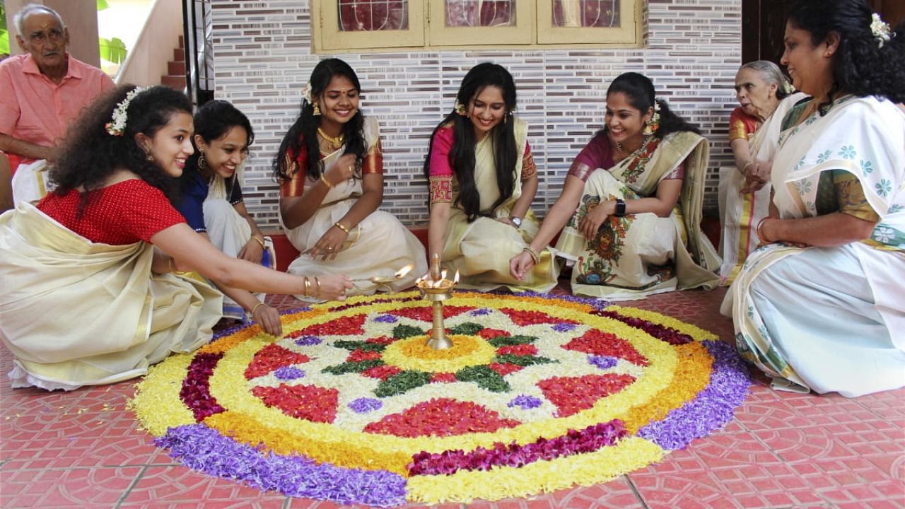 Kerala women make a Pookkalam (floral art) to celebrate Onam festival, in Bengaluru. Credit: PTI Photo
