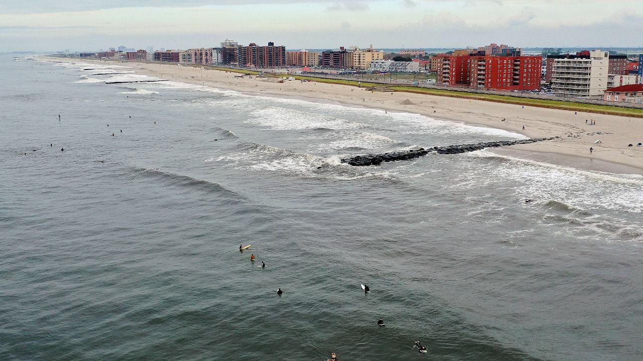 In an aerial view, surfers flock to the beach as wave heights elevate in advance of Hurricane Henri on August 21, 2021 in Long Beach, New York. Credit: AFP Photo