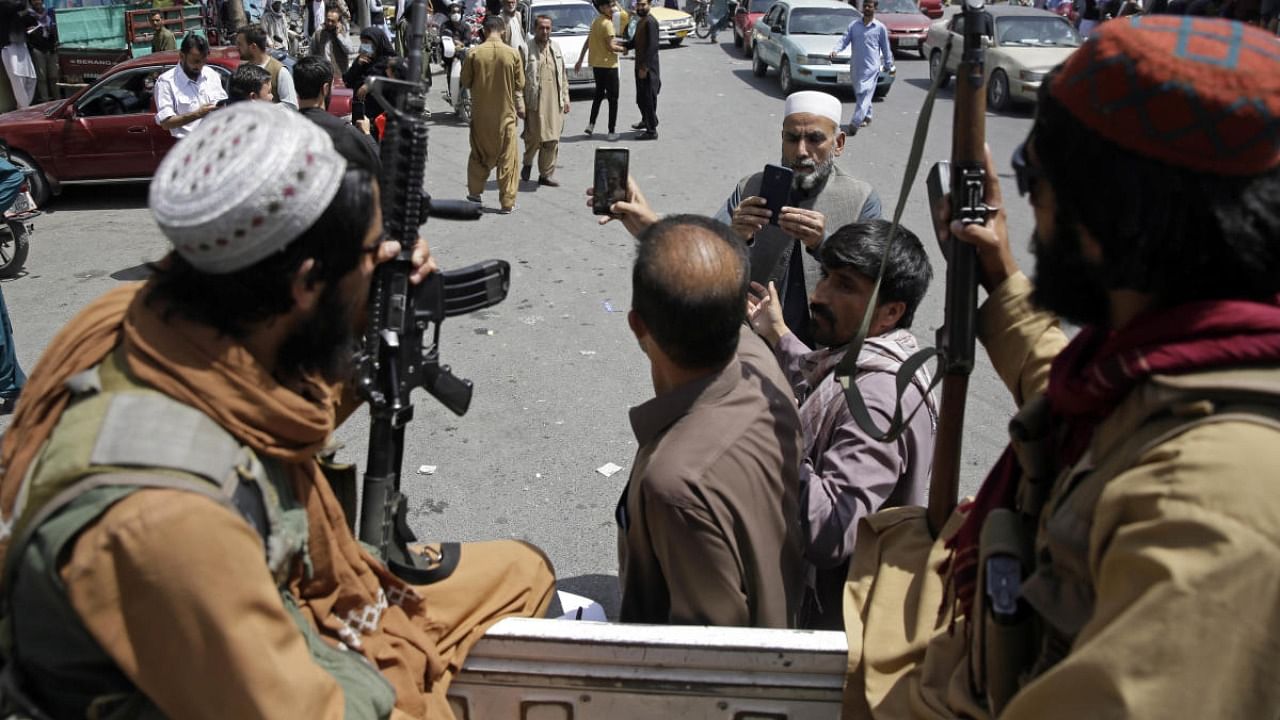 Afghans take selfie wit Taliban fighters during patrol in the city of Kabul. Credit: AP/PTI photo