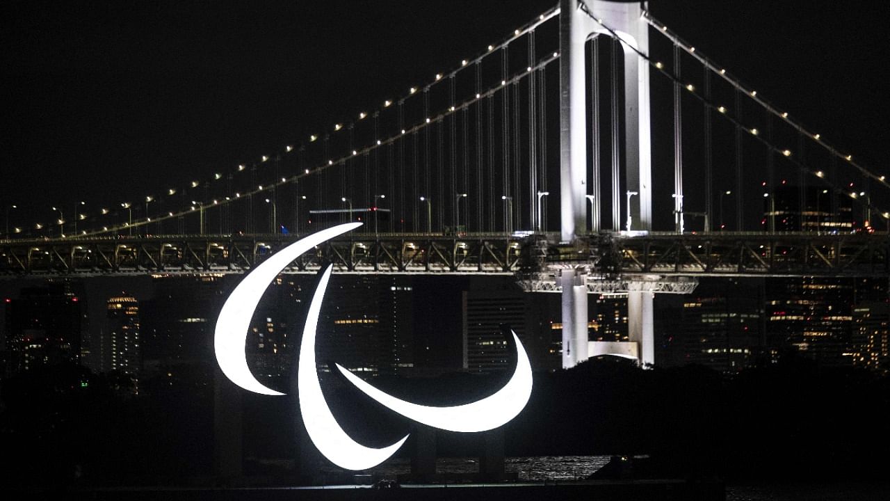 A general view shows the Paralympics symbol rings lit up at night, with the Rainbow bridge in the background. Credit: AFP Photo