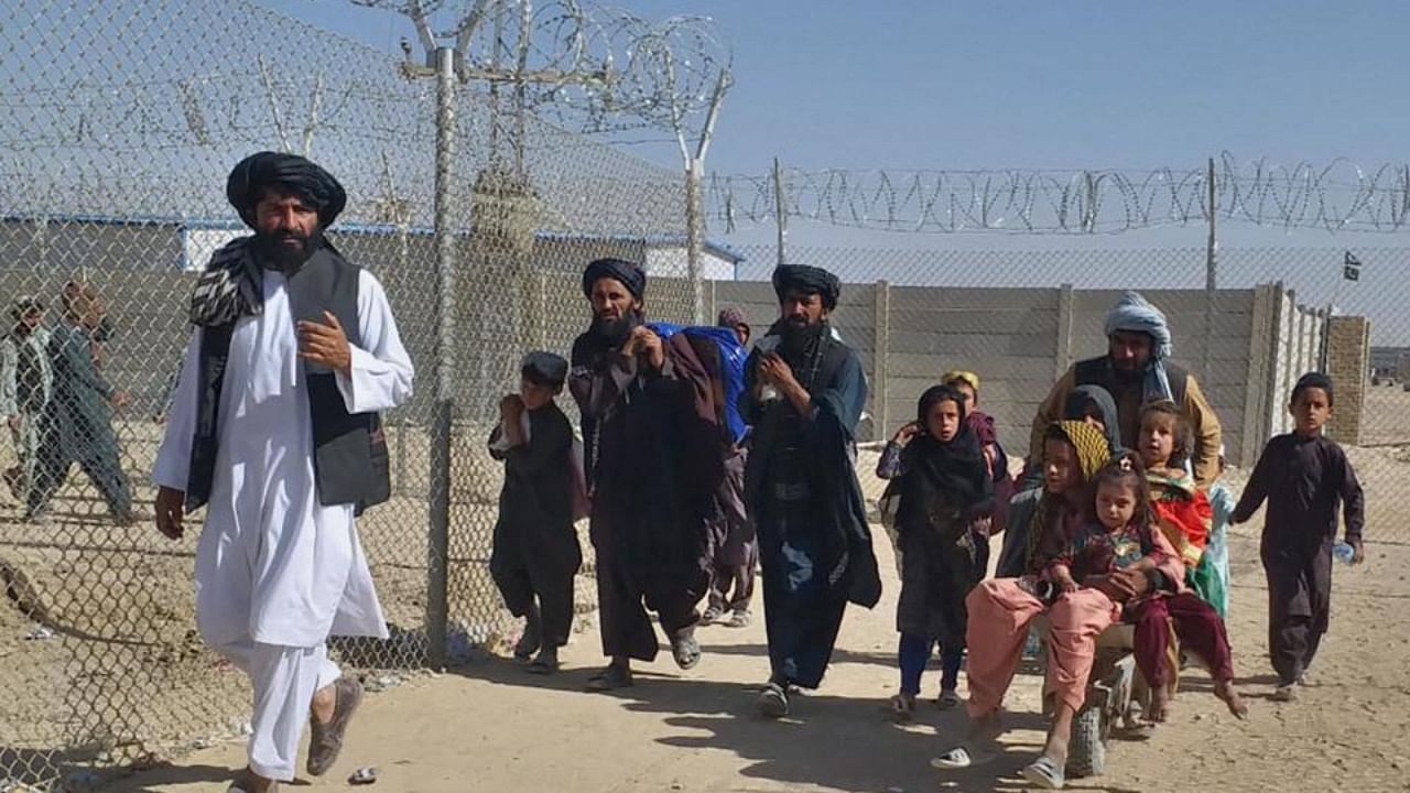 Afghan families enter into Pakistan through a border crossing point in Chaman, Pakistan, Sunday, Aug. 22, 2021. Credit: PTI Photo