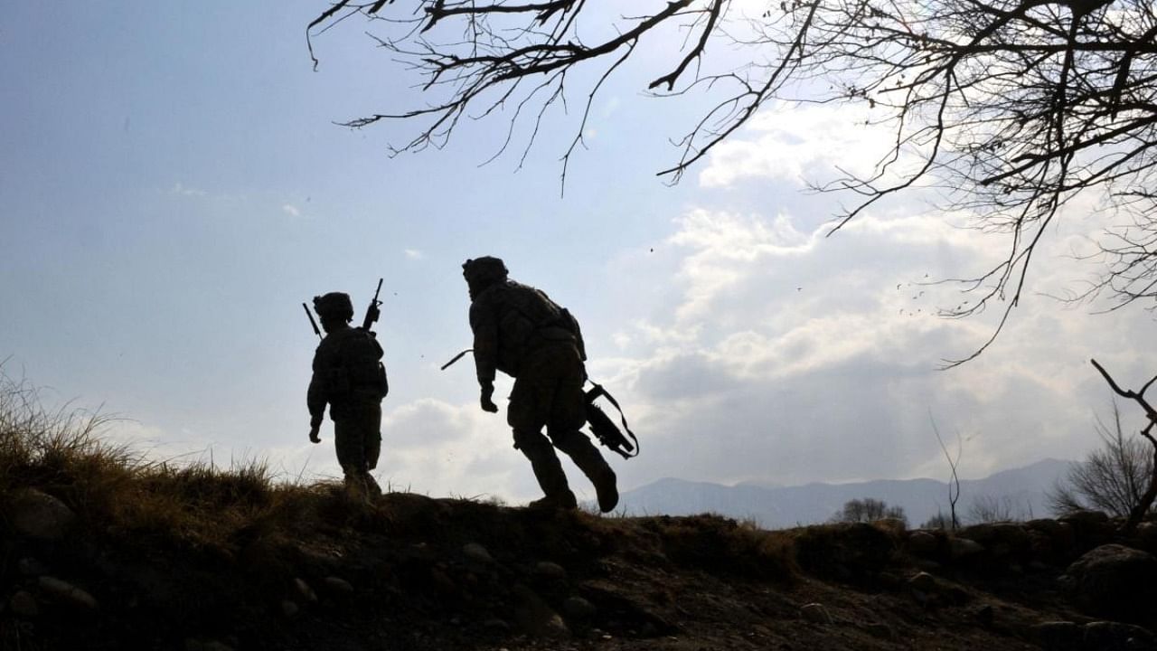 US soldiers with the 4th Infantry Division, 4th Infantry Brigade Combat Team, Alpha Company, scale a hill while on patrol in Markikheyl in eastern Afghanistan's Nangarhar province in 2010. Credit: AFP Photo
