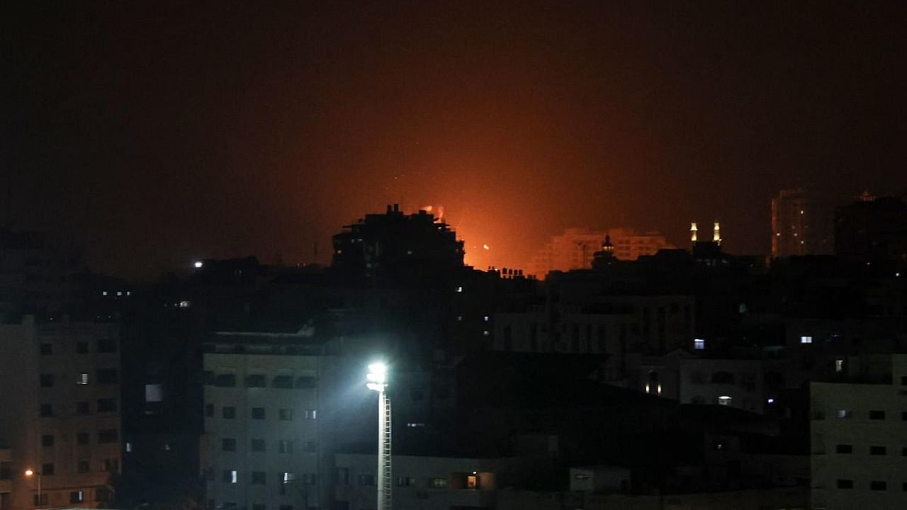 Explosions light-up the night sky above buildings in Gaza City as Israeli forces shell the Palestinian enclave. Credit: AFP Photo
