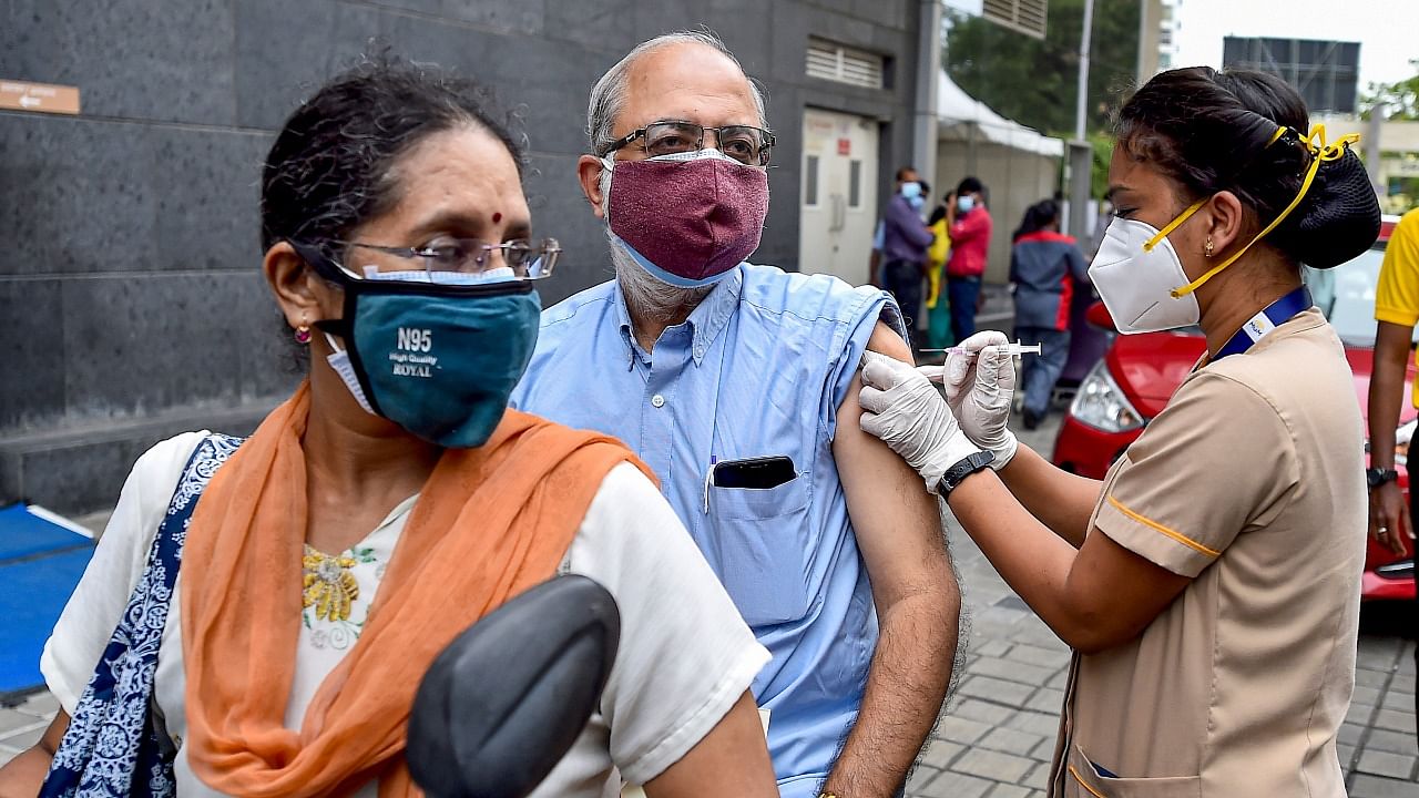 A health worker administers a dose of the Covid-19 vaccine to a person at a drive-in vaccination centre in Chennai. Credit: PTI File Photo