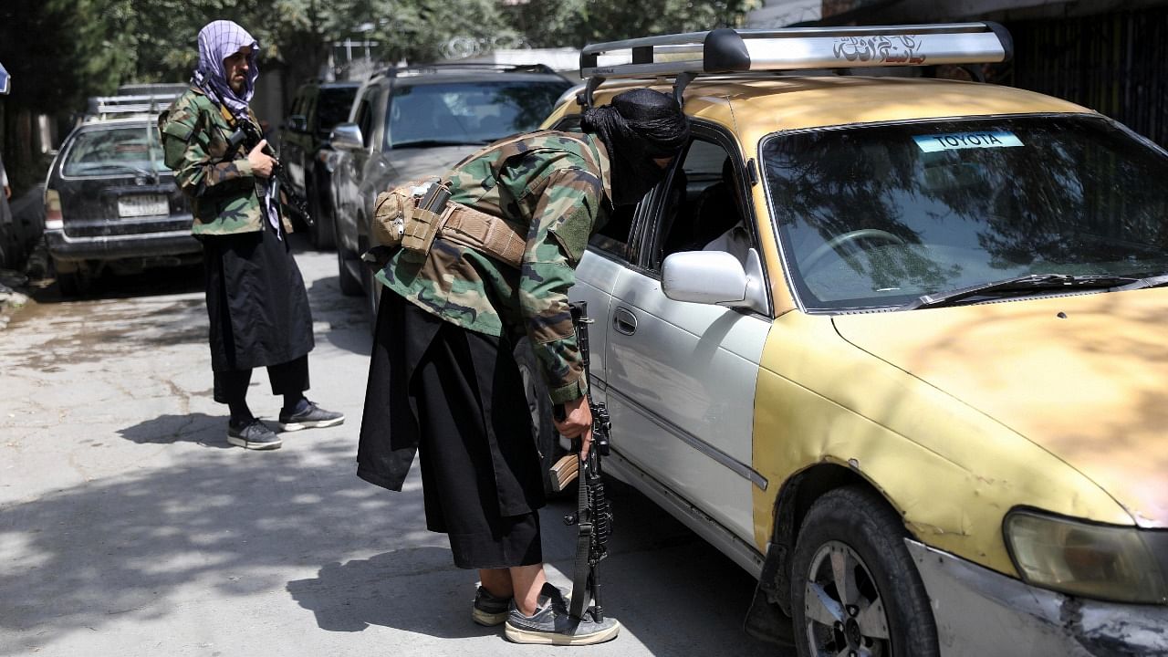 Taliban fighters search a vehicle at a checkpoint on the road in the Wazir Akbar Khan neighborhood in Kabul, Afghanistan. Credit: AP/PTI Photo