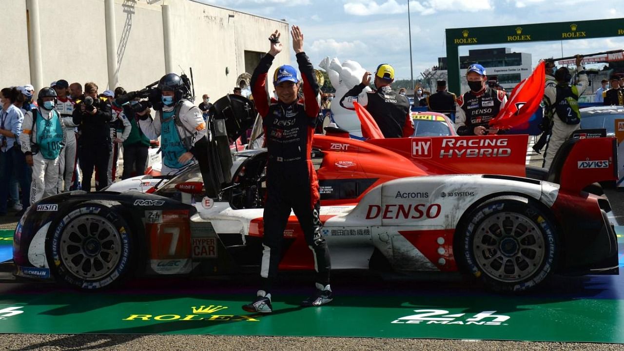 Toyota TS050 Hybrid Hypercar WEC's Japanese driver Kamui Kobayashi celebrates next to his car after winning the 89th edition of the Le Mans 24 Hours endurance race. Credit: AFP Photo