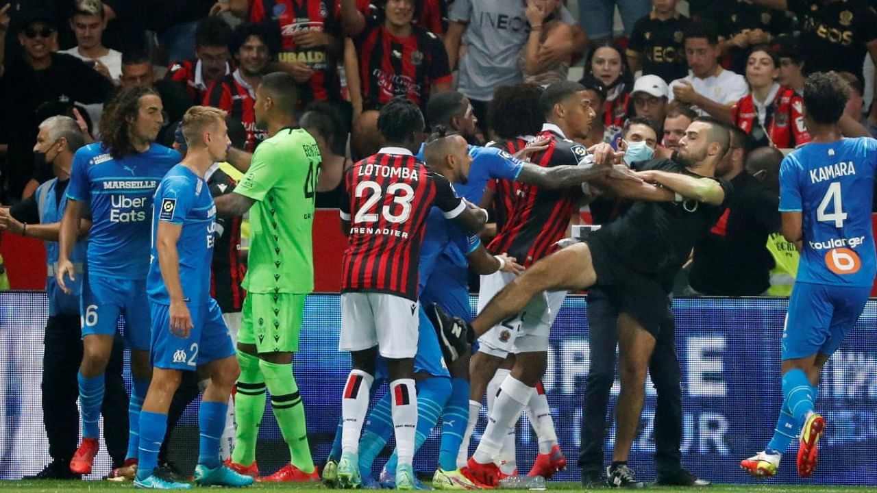 Pitch invaders clash with players as the game is interrupted. Credit: Reuters Photo