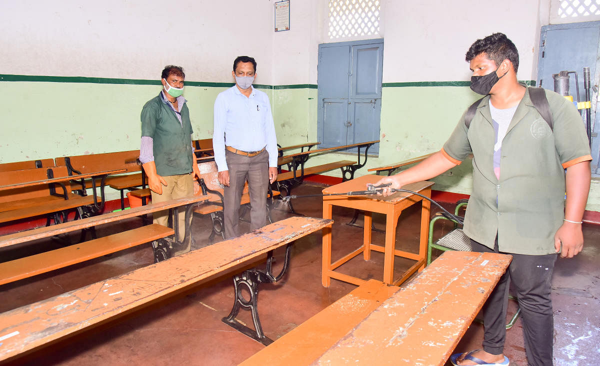 A file picture of sanitisation of a classroom at a school in Mysuru. The classes for 9-12 standard are set to reopen on Monday, after being suspended for more than a year due to Covid pandemic. DH Photo