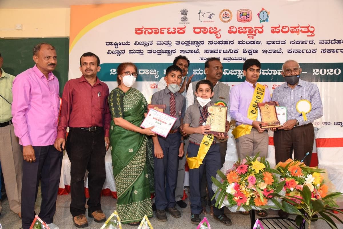 C S Raghuvamshi and K K Mahin receive prizes from dignitaries in Bengaluru.