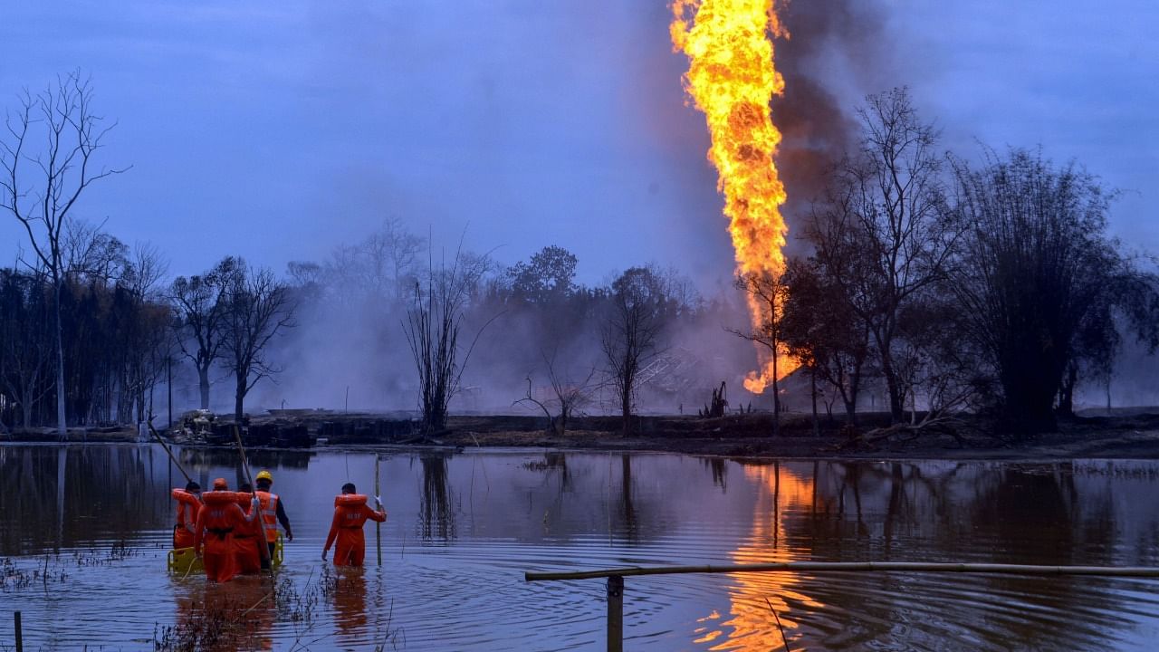 NDRF personnel search for the missing fire-fighters at a pond near an oil well as Baghjan oil field continues to burn. Credit: PTI File Photo