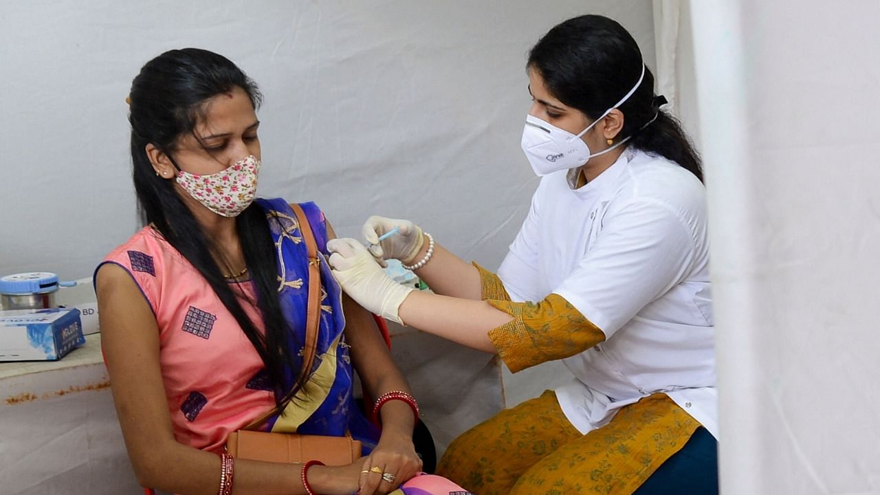 A health worker injects a woman with a dose of the Covishield Covid-19 vaccine in Mumbai on August 23, 2021. Credit: AFP Photo