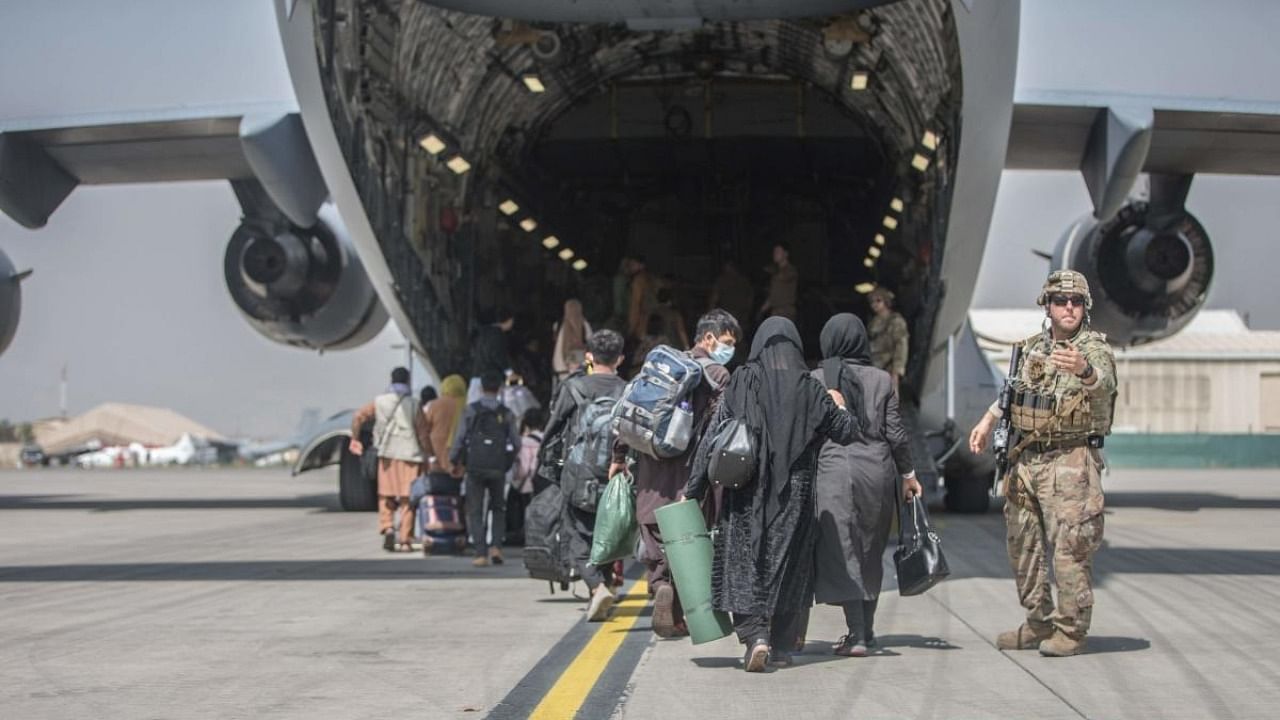 Families begin to board a US Air Force Boeing C-17 Globemaster III during an evacuation at Hamid Karzai International Airport, Kabul. Credit: AFP Photo