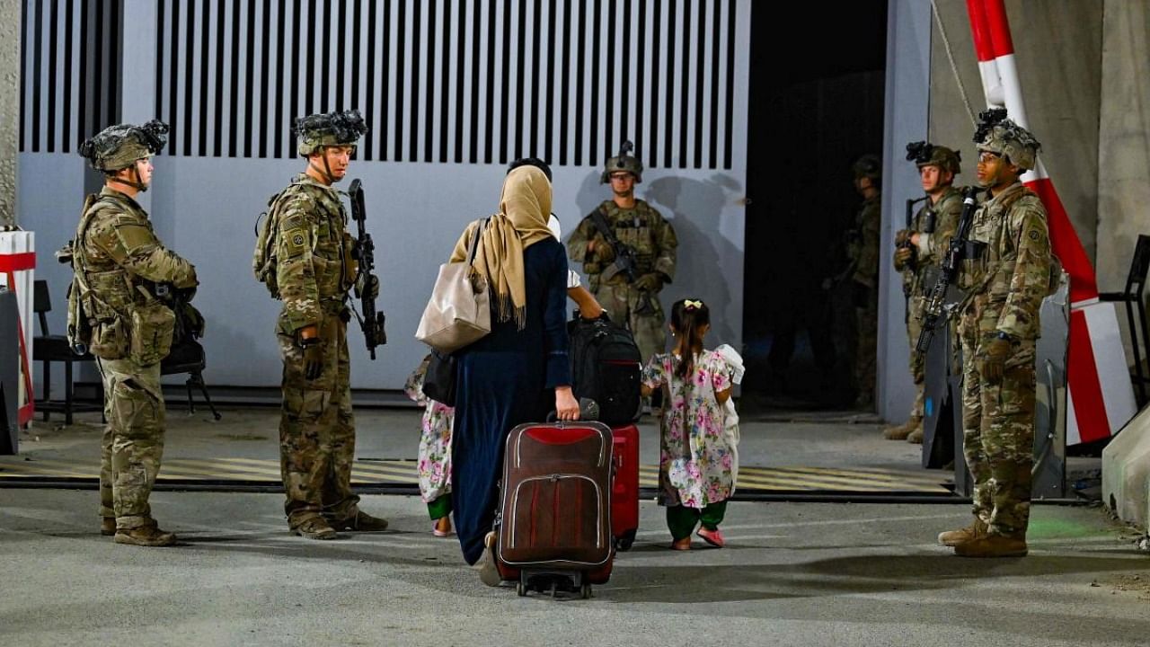 In this image courtesy of the US Central Command Public Affairs, paratroopers assigned to the 1st Brigade Combat Team, 82nd Airborne Division, based out of Fort Bragg, North Carolina, facilitate the safe evacuation of US citizens, Special Immigrant Visa applicants, and other at-risk Afghans out of Afghanistan from Hamid Karzai International Airport in Kabul, on August 22, 2021. Credit: AFP Photo