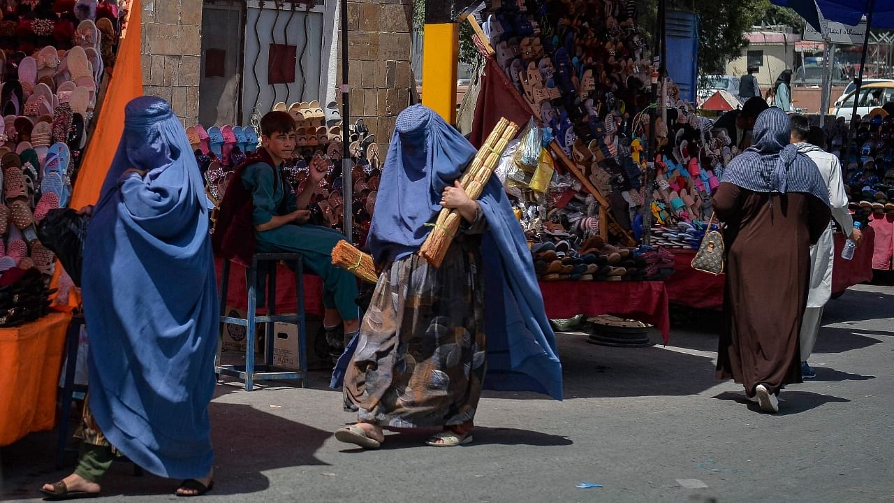 Burqa clad Afghan women shop at a market area in Kabul. Credit: AFP Photo