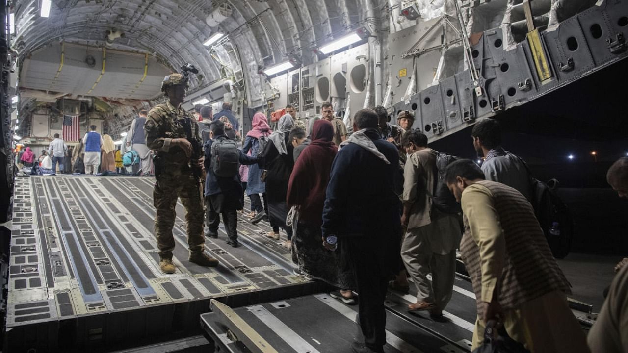 Afghan passengers board a U.S. Air Force C-17 Globemaster III during the Afghanistan evacuation at Hamid Karzai International Airport in Kabul, Afghanistan. Credit: AP Photo