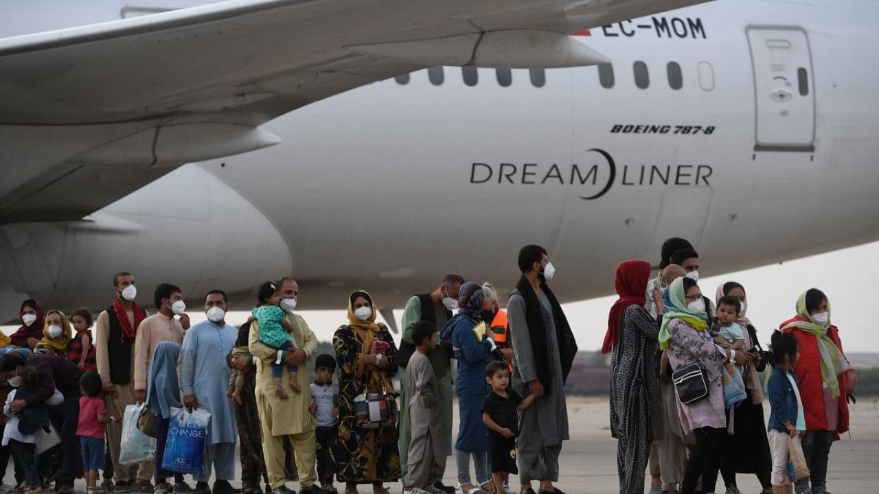 Refugees queue on the tarmac after disembarking from an evacuation flight from Kabul. Credit: AFP Photo