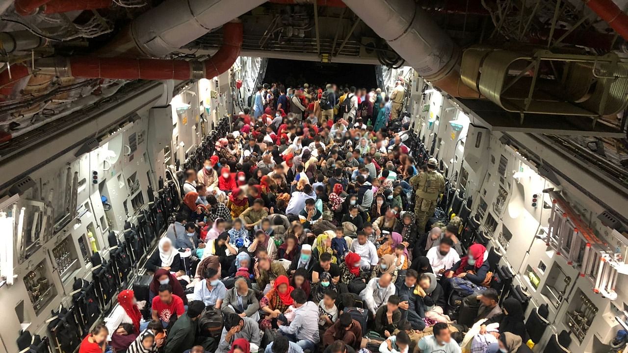 Evacuees sit in an RCAF C-177 Globemaster III transport plane en route to Canada. Credit: Reuters Photo