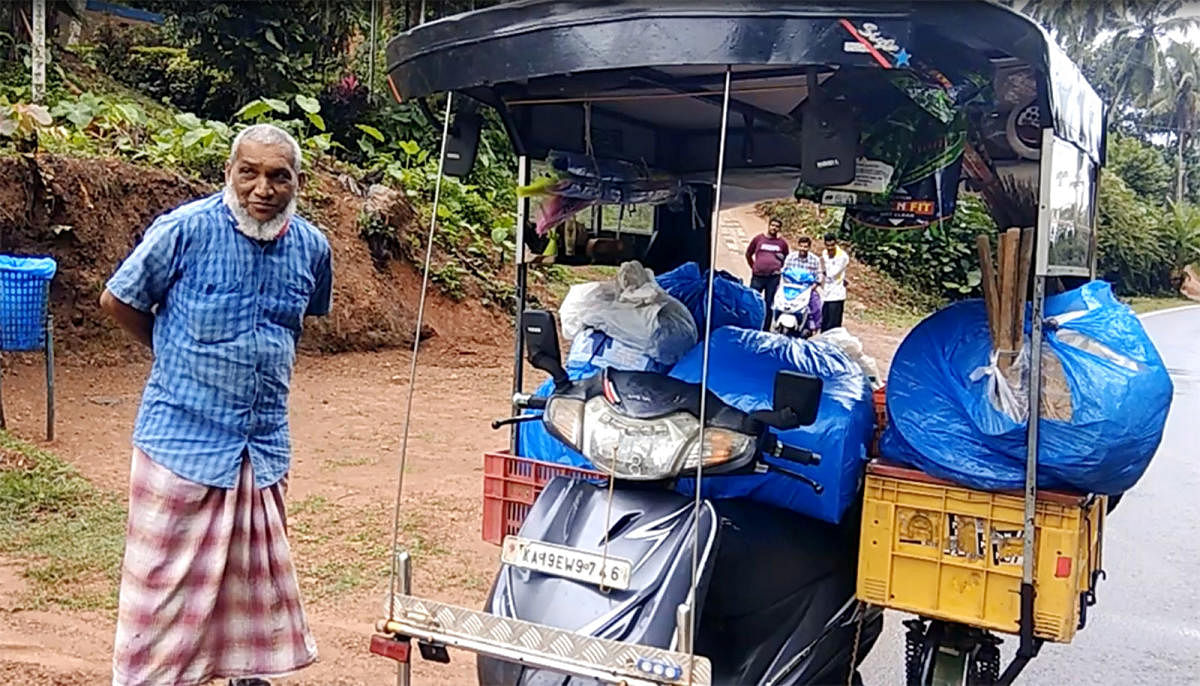 Abdul Khader with his vehicle in which he sells essential items and collects waste.