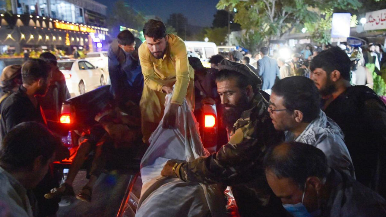 Volunteers and medical staff unload bodies from a pickup truck outside a hospital. Credit: AFP Photo