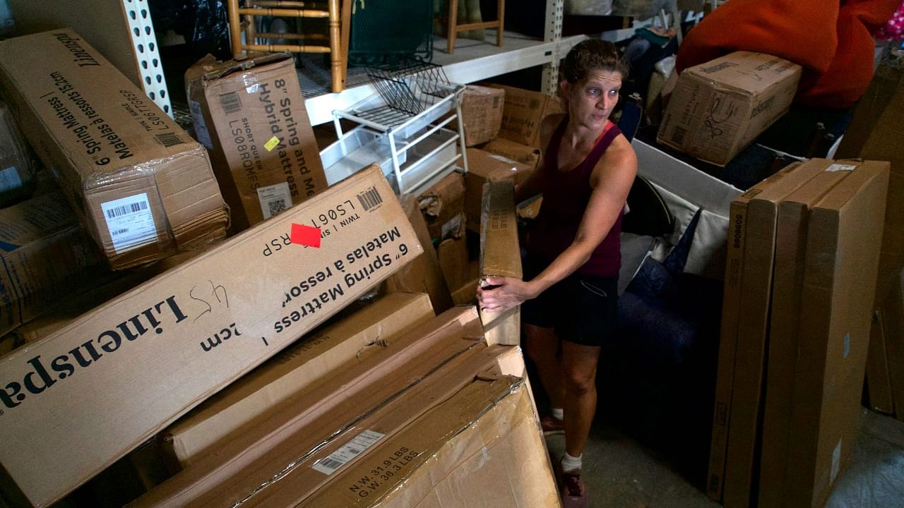 Laura Thompson Osuri, executive director of Homes Not Borders, a nonprofit helping refugees, asylum seekers and Special Immigrant Visa holders settle in the US, lifts a box in a warehouse holding donated goods and furniture in Landover, Maryland. Credit: AFP Photo