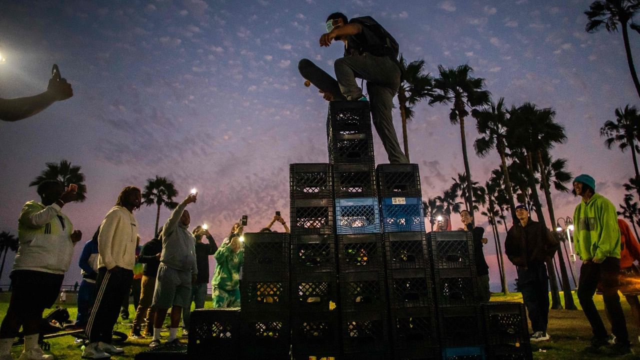 A man walks up a pyramid of milk crates while he participates of the Milk Crate Challenge, on August 24, 2021 in Venice, California. Credit: AFP Photo