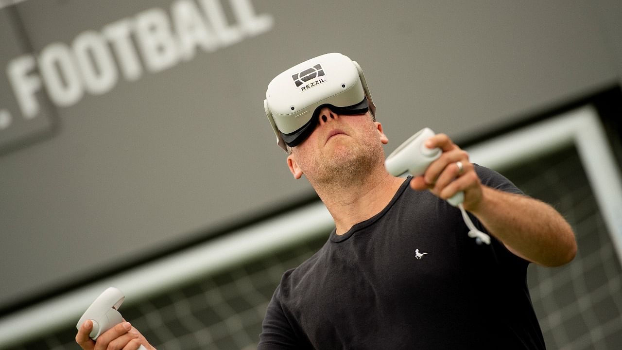 A man checks the virtual reality headset "Player 22" by Rezzil, used by pro footballers to combat the risks of concussion from heading. Credit: Reuters Photo