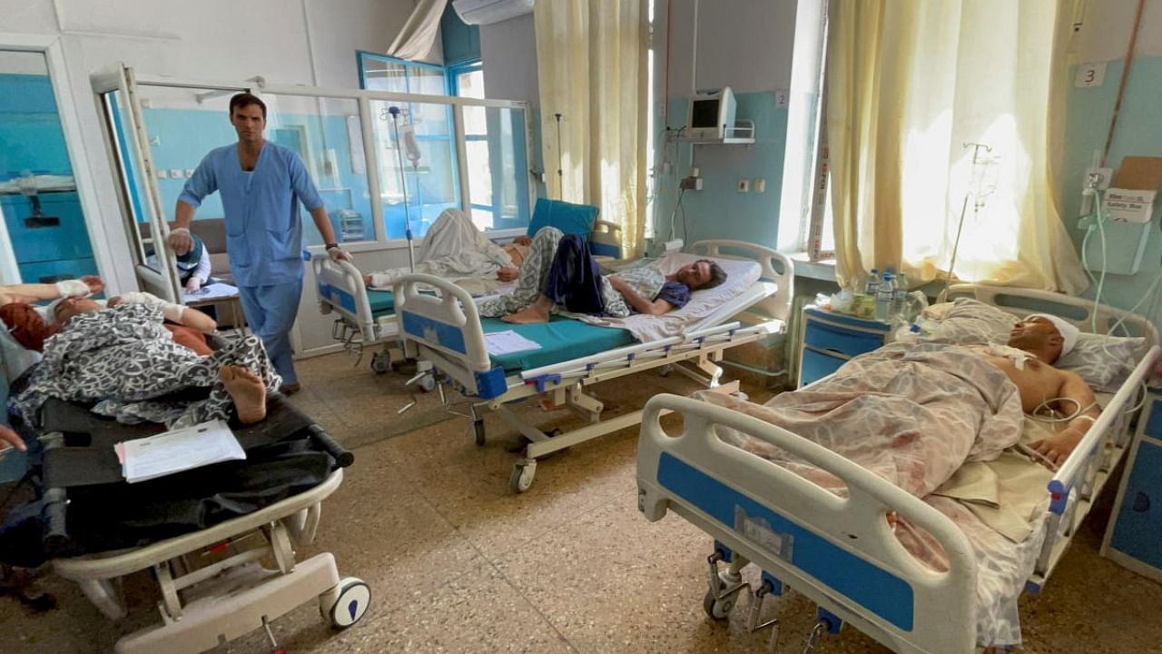 Wounded Afghan men receive treatment at a hospital after explosions outside airport in Kabul. Credit: Reuters photo