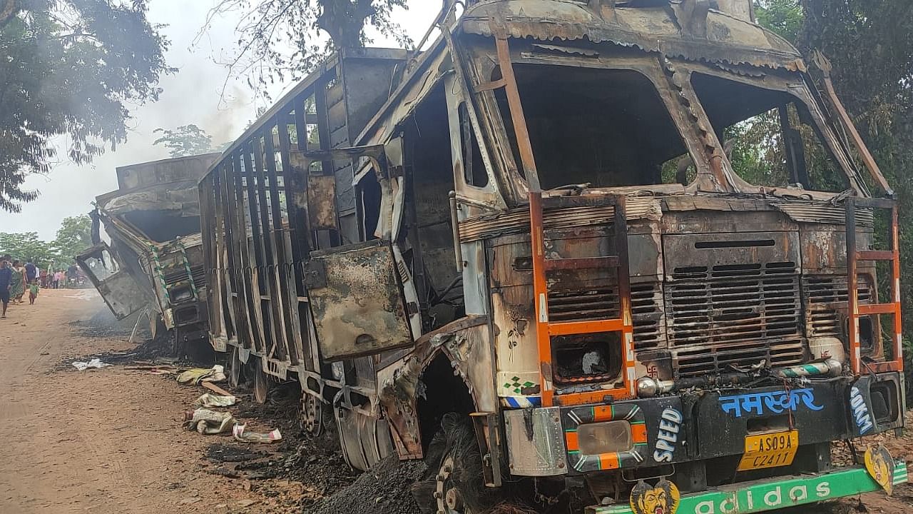 Charred remains of the trucks after they were set ablaze by the suspected militants. Credit: DH Special Arrangement 
