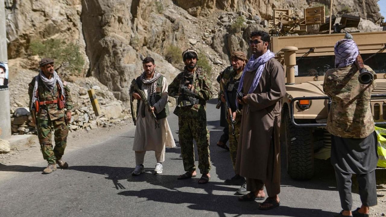 Afghan resistance movement and anti-Taliban uprising forces patrol along a road at the Rah-e Tang in Panjshir province. Credit: AFP Photo