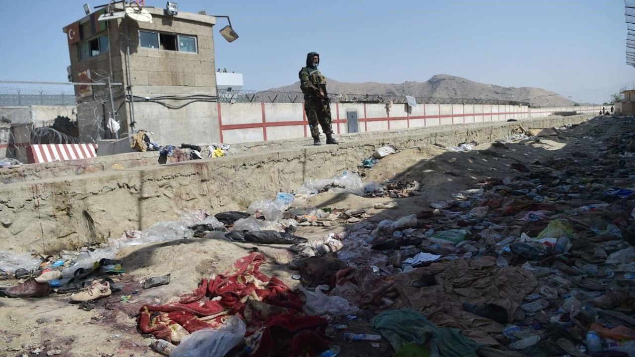 A Taliban fighter stands guard at the site of the August 26 twin suicide bombs at Kabul airport. Credit: AFP Photo
