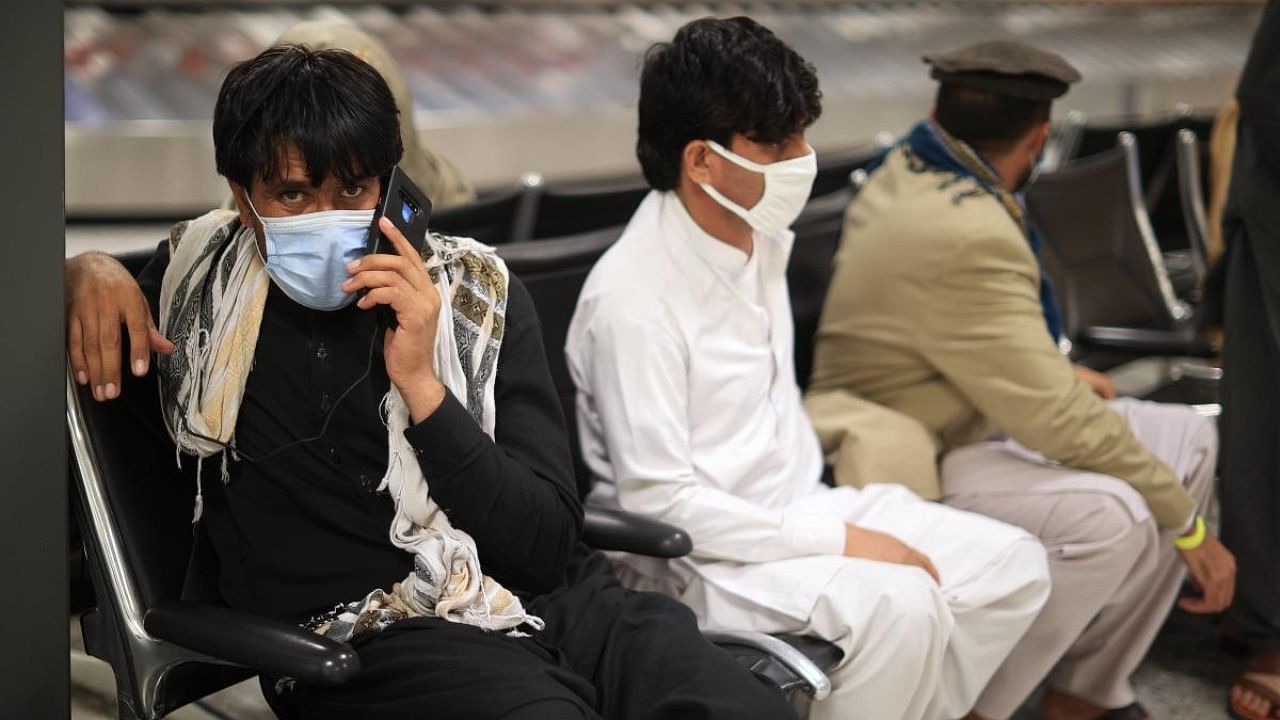 Refugees wait for transportation at Dulles International Airport after being evacuated from Kabul following the Taliban takeover of Afghanistan August 27, 2021 in Dulles, Virginia. Credit: AFP Photo