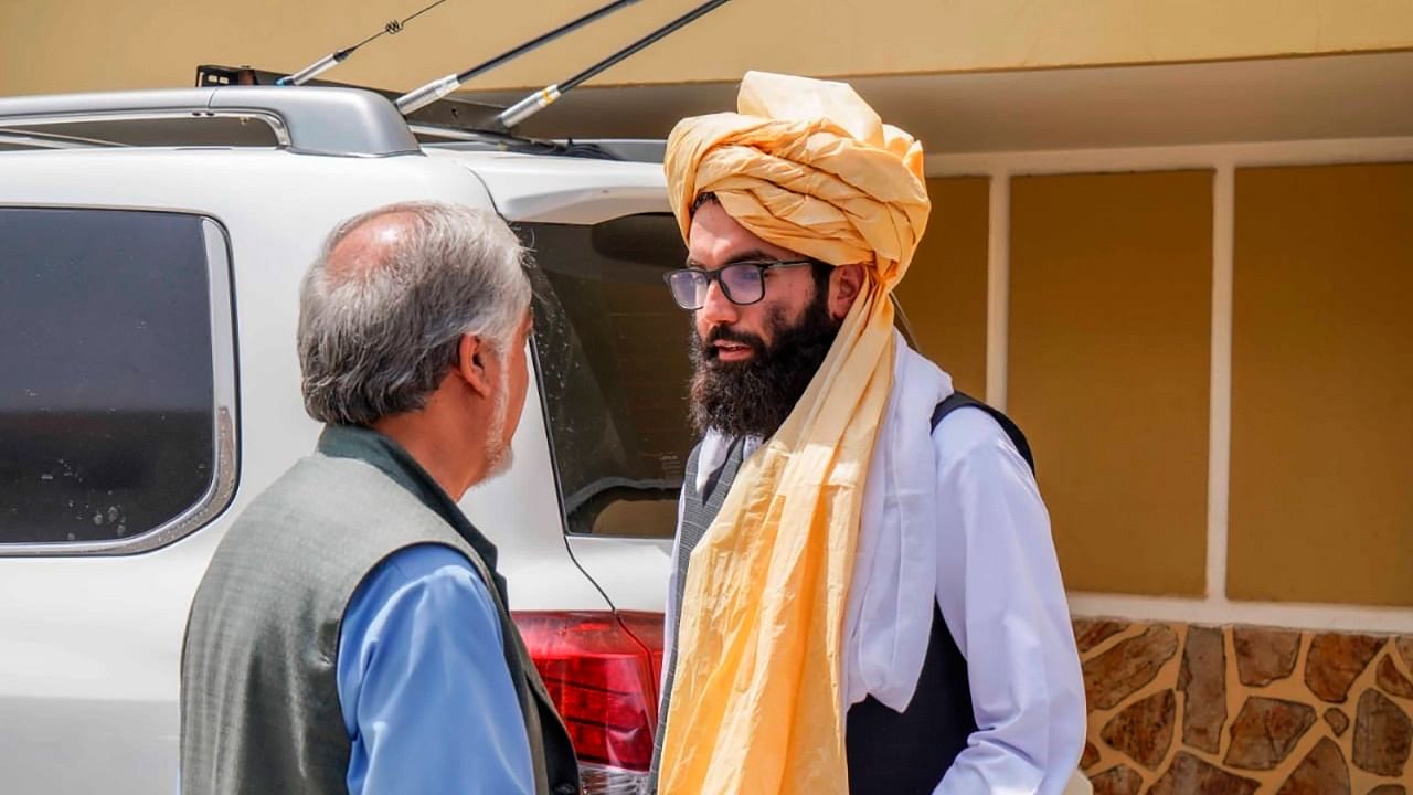 In this handout photograph released by the Taliban, senior Haqqani group leader Anas Haqqani, right, speaks to Abdullah Abdullah, head of Afghanistan's National Reconciliation Council and former government negotiator with the Taliban, in Kabul. Credit: AP/PTI photo