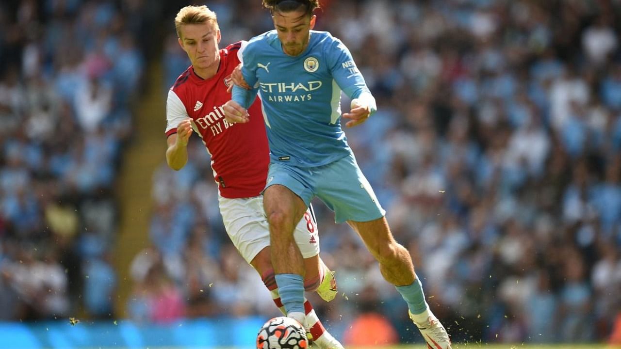Arsenal's Norwegian midfielder Martin Odegaard (L) vies with Manchester City's English midfielder Jack Grealish during the English Premier League football match between Manchester City and Arsenal at the Etihad Stadium in Manchester. Credit: AFP Photo