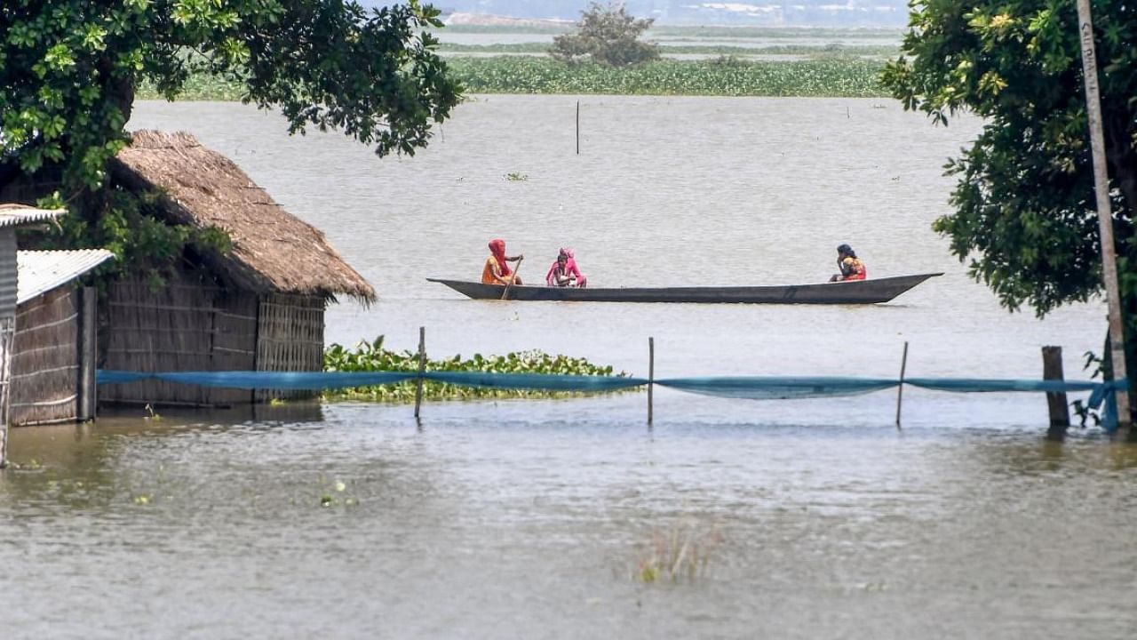 Villagers on a boat cross a flooded area in Morigaon district, Tuesday, Aug. 24, 2021. Credit: PTI Photo