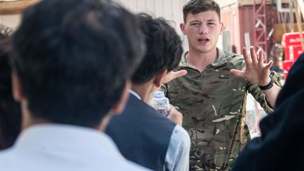 UK Armed Forces talking to people during a deployment to support the evacuation of British nationals and entitled personnel at Kabul airport in Afghanistan. Credit: AFP File Photo