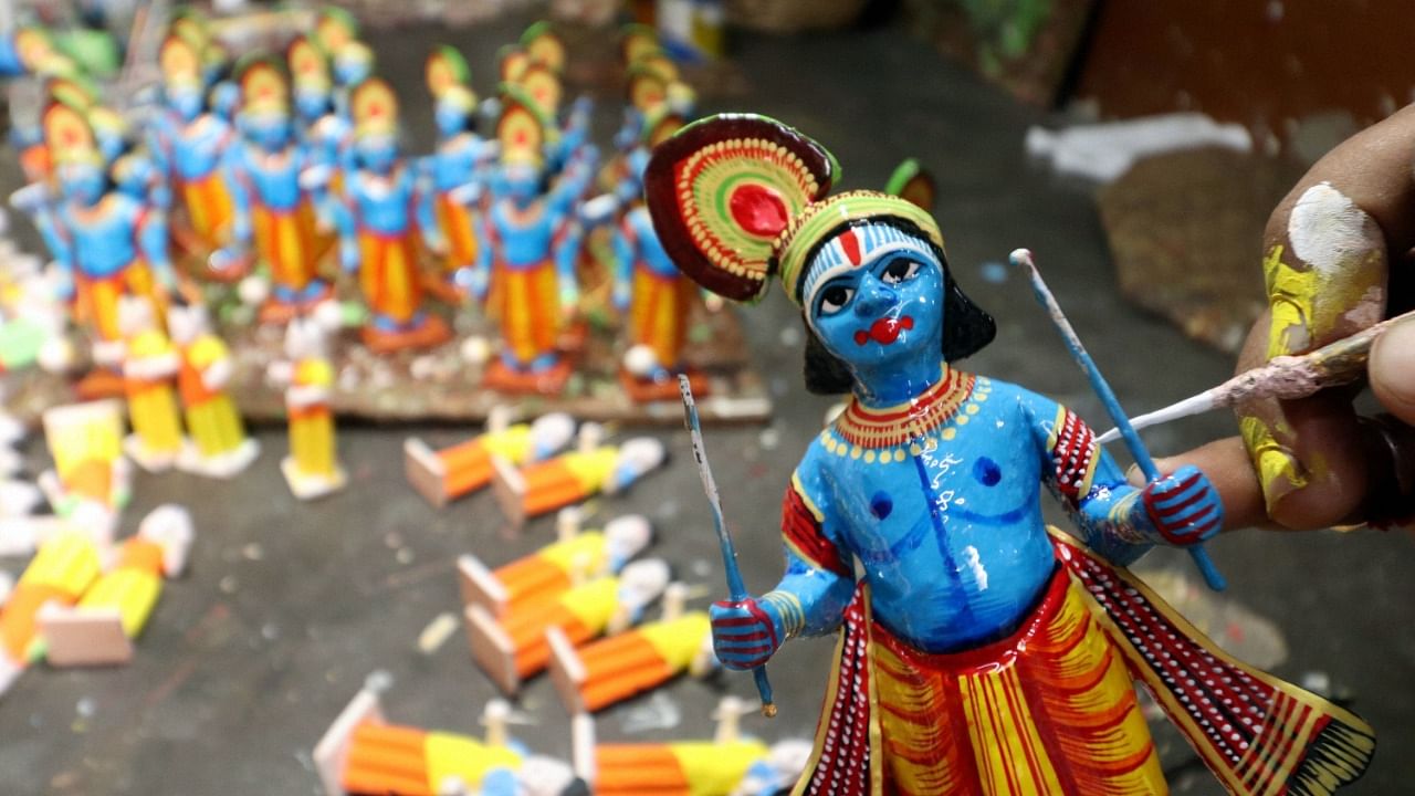 An artist gives a final touch to the wooden idol of Lord Krishna at his workshop, ahead of the Janmashtami festival in Varanasi, Wednesday. Credit: PTI Photo
