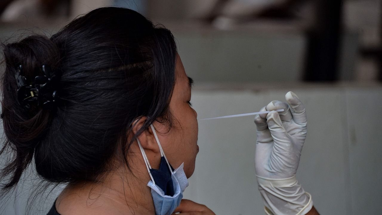 A health worker takes a swab sample. Credit: AFP Photo