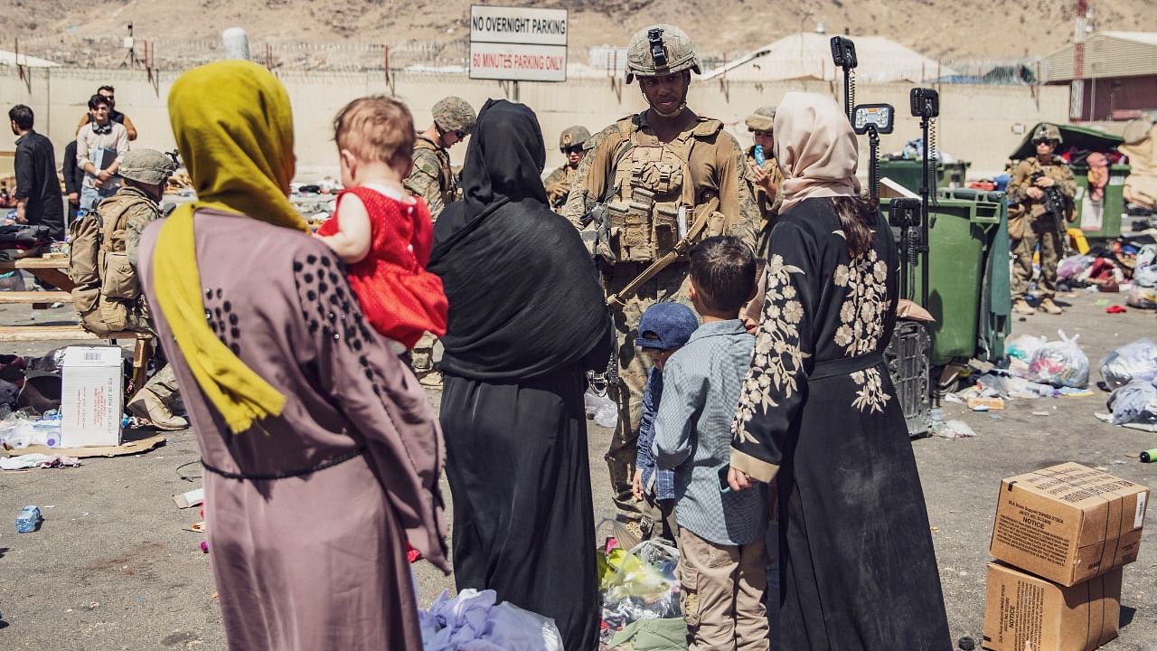 US Marines with the 24th Marine Expeditionary Unit (MEU) process evacuees as they go through the Evacuation Control Center (ECC) during an evacuation at Hamid Karzai International Airport, Kabul, Afghanistan, August 28, 2021. Credit: Reuters Photo