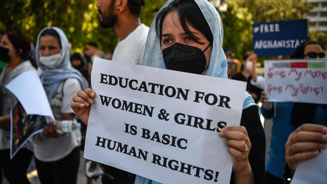 A protester holds a placard during a demonstration of members of the Afghan community outside the US embassy in Athens after the Taliban swept to power in Afghanistan. Credit: AFP Photo