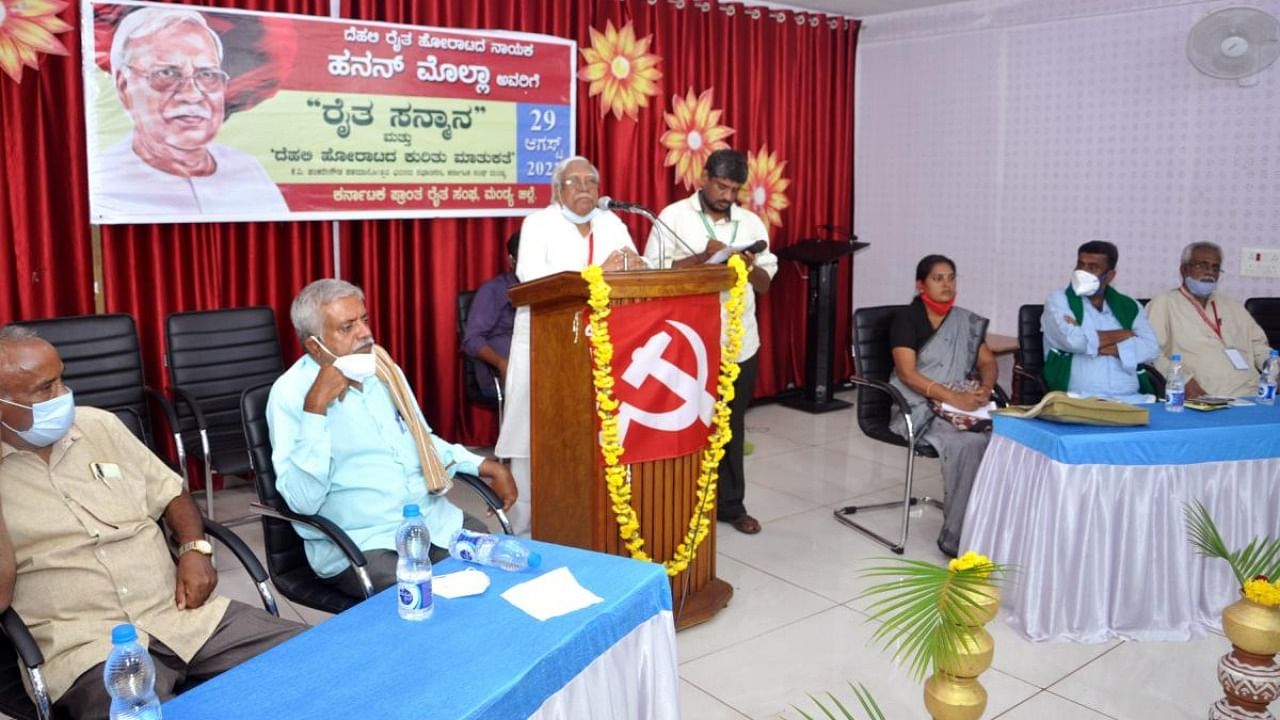 Farmers' leader Hannan Mollah speaks during a programme in Mandya on Sunday. Credit: DH Photo