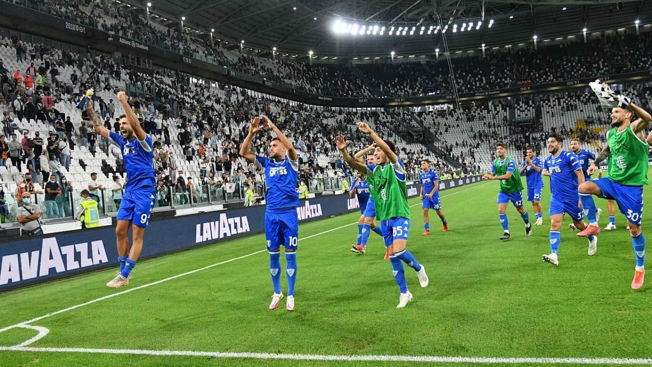 Empoli's players, with Juventus' Spanish forward Alvaro Morata (L) and Empoli's Albanian midfielder Nedim Bajrami, celebrate their victory at the end of the Italian Serie A football match Juventus vs Empoli at Allianz Stadium in Turin. Credit: AFP Photo