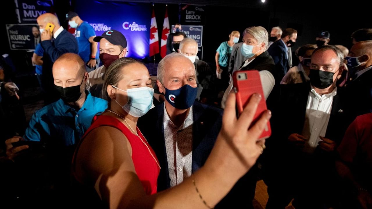 Leader of the Conservative Party of Canada, Erin O'Toole, takes a photo with a supporter at a campaign stop in Hamilton, Ontario. Credit: Reuters photo